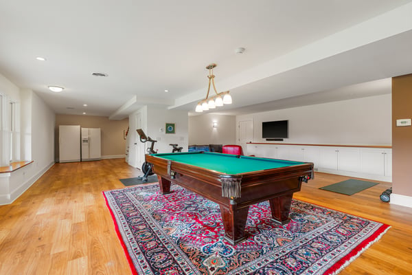 Spacious recreational room featuring a pool table, exercise equipment, and ample storage for entertainment needs.