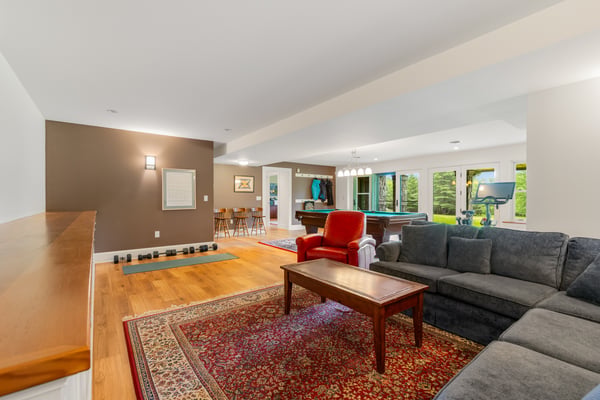 Spacious living area features a cozy seating arrangement and a versatile space for entertainment and fitness.