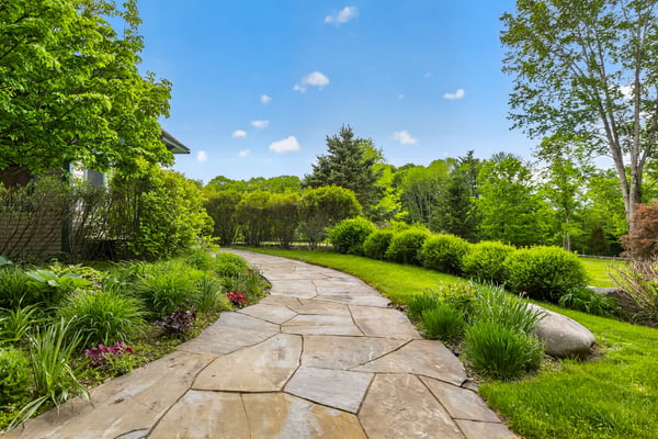 This inviting pathway leads through vibrant landscaping, showcasing a lush, green outdoor retreat ready for enjoyment.