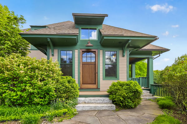 This distinctive home features a unique architectural design and inviting front entry, surrounded by lush landscaping.