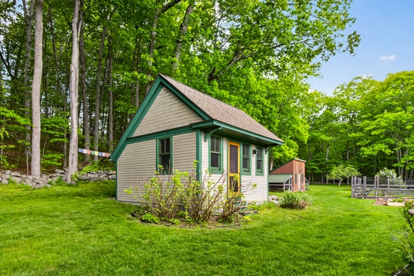 Cozy cottage surrounded by lush greenery, offering a peaceful retreat and ample outdoor space for relaxation.