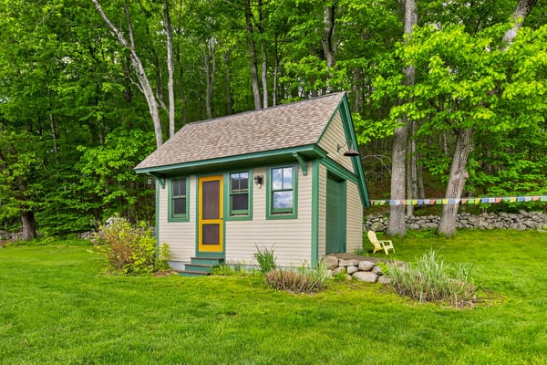 Quaint cottage nestled in lush greenery, featuring vibrant accents and a peaceful outdoor space for relaxation.