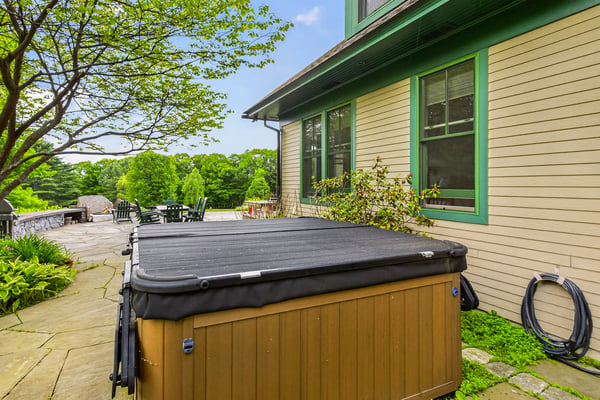 Discover a private outdoor oasis featuring a hot tub and ample space for relaxation and entertainment.