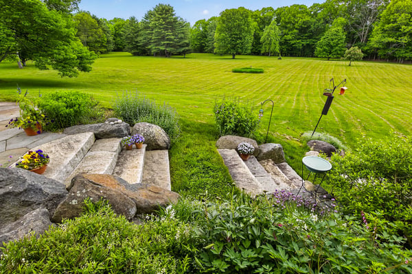 Discover a tranquil outdoor retreat featuring landscaped steps leading to expansive, lush greenery and open space.