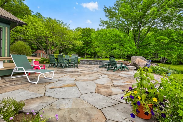 Spacious outdoor patio surrounded by lush greenery, perfect for gatherings and enjoying nature's beauty.