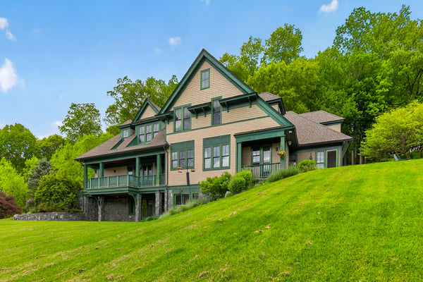Spacious home nestled on a lush hillside, featuring extensive outdoor space and scenic natural views.