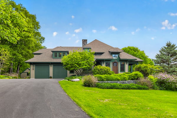 This spacious home features a unique architectural design, surrounded by lush landscaping and ample outdoor space.
