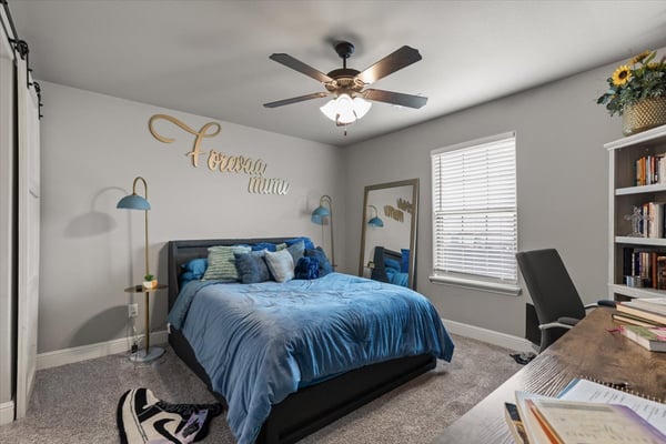 Spacious bedroom featuring natural light from large windows.