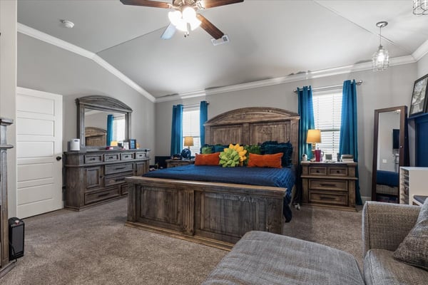 Spacious primary suite featuring high ceilings, ample natural light, and a cozy seating area for relaxation.