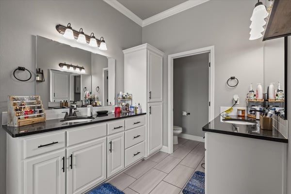 Modern bathroom featuring dual sinks, ample storage, and contemporary fixtures, perfect for daily routines.