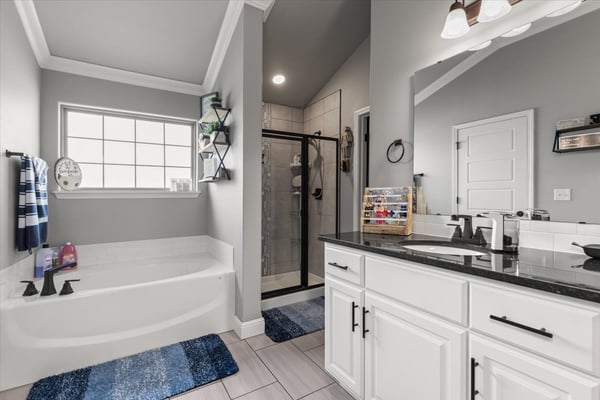 Spacious bathroom featuring a dual vanity, walk-in shower, and generous soaking tub for relaxation.