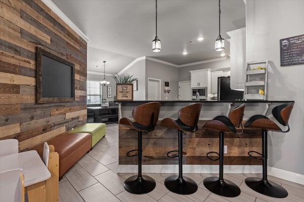 Contemporary kitchen with a unique wood accent wall and inviting bar seating for casual dining and entertaining.