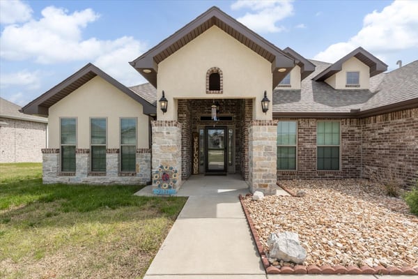 Discover a welcoming entrance with a blend of brick and stone, featuring abundant natural light.