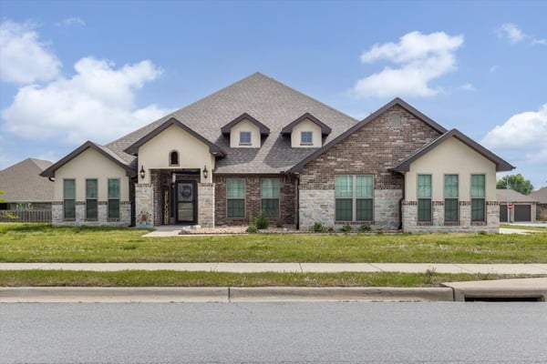 Spacious home featuring a unique design, ample natural light, and an inviting front yard in a vibrant neighborhood.