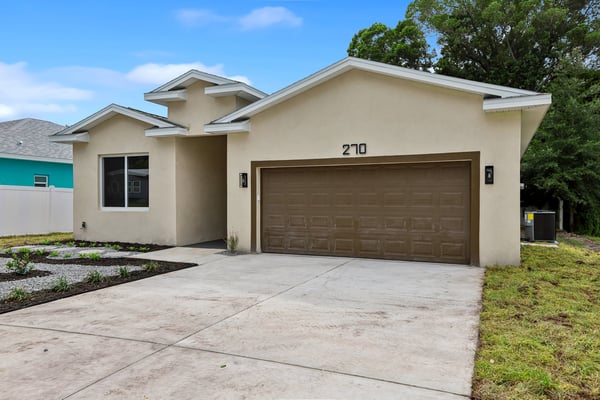 Modern single-family home featuring a spacious garage and low-maintenance landscaping, perfect for contemporary living.