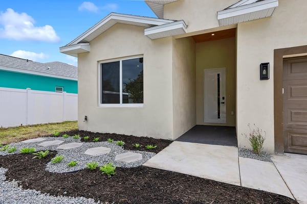 Contemporary home entrance featuring a spacious porch and low-maintenance landscaping, perfect for outdoor enjoyment.