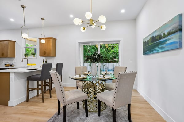 Bright and inviting dining area featuring modern furnishings and natural light, perfect for gatherings and meals.