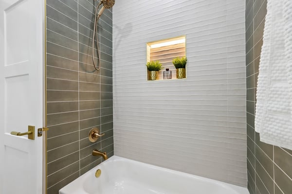 Contemporary bathroom featuring modern fixtures, a built-in niche for toiletries, and sleek tile accents.