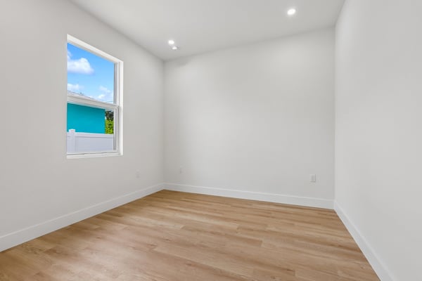 Bright and spacious room featuring large windows and modern flooring, perfect for various uses.