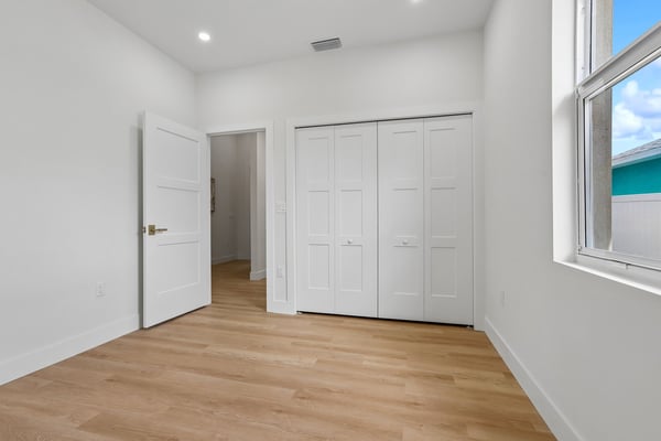 Bright and airy bedroom featuring ample natural light and spacious closets in a modern design.