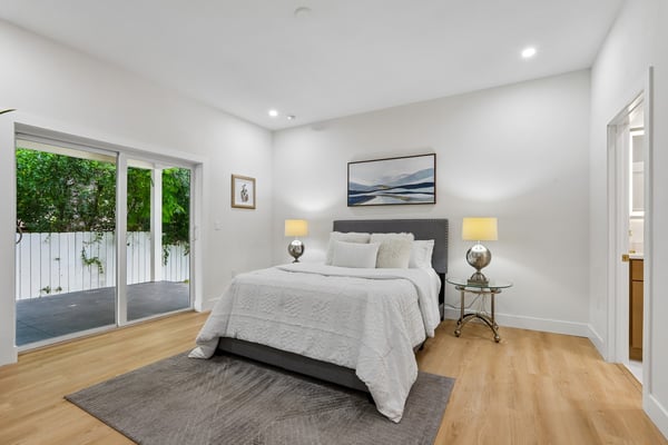 Bright and airy bedroom featuring large sliding doors, designed for comfort and modern living.