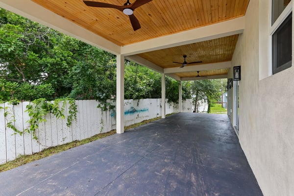 Spacious covered patio offers a perfect spot for outdoor gatherings, surrounded by lush greenery and privacy.