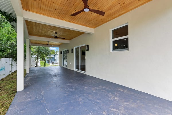 Spacious covered patio with modern ceiling fans, perfect for outdoor gatherings and relaxation.