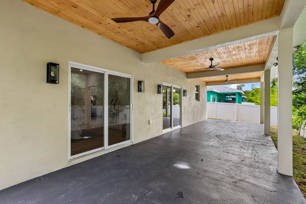 Spacious covered patio with ceiling fans, perfect for outdoor gatherings and enjoying the fresh air.