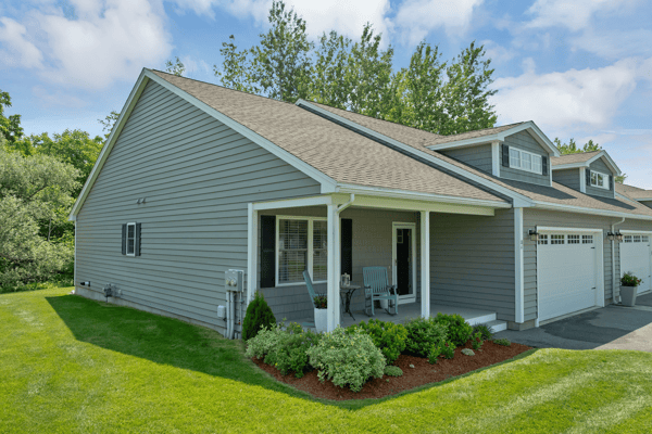 Welcoming home featuring a spacious front yard, ample natural light, and convenient parking.
