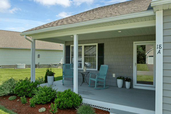 Inviting porch setup with greenery and seating, perfect for enjoying morning coffee in a quiet neighborhood.