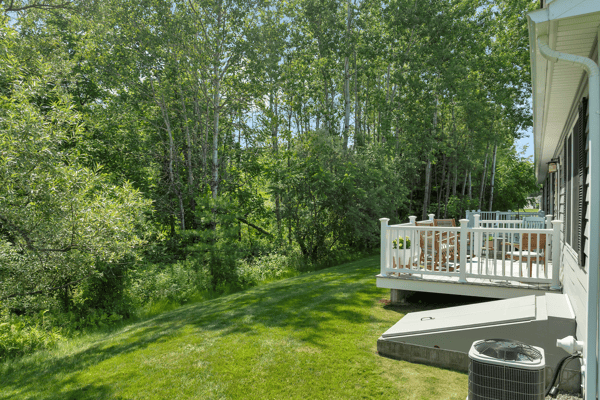 Spacious backyard borders lush greenery, ideal for outdoor gatherings and peaceful retreats. Perfect for nature lovers!