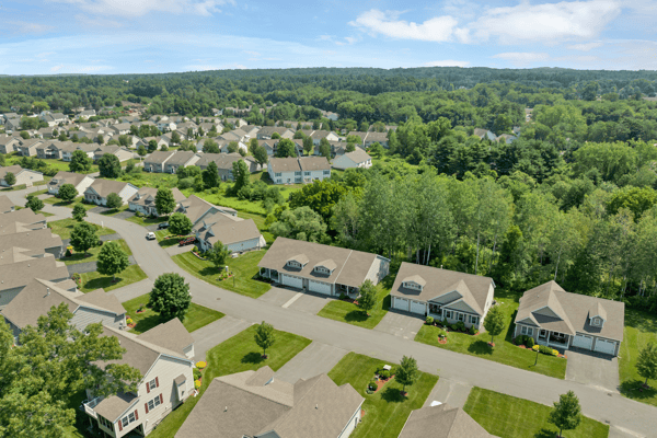 Spacious community with well-maintained homes, surrounded by lush greenery and convenient access to local amenities.