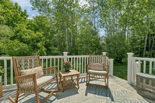 Enjoy peaceful outdoor gatherings on this spacious deck surrounded by lush greenery and a tranquil atmosphere.