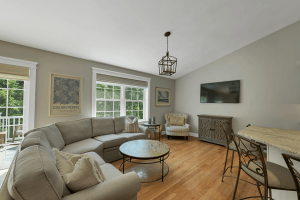 Bright and inviting living area features large windows, cozy seating, and a seamless flow to outdoor space.