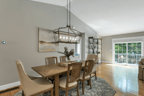 Bright dining area featuring a modern light fixture, perfect for intimate gatherings and open to lush views.
