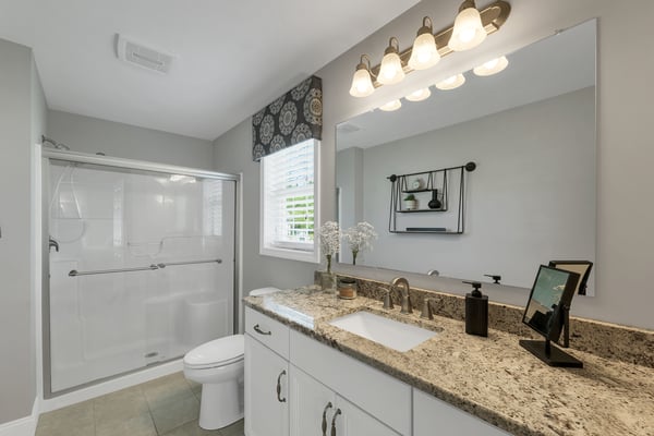 Bright and modern bathroom featuring a spacious countertop, sleek fixtures, and natural light from the window.
