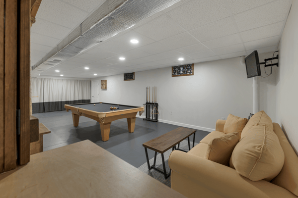 Spacious recreation room featuring a pool table, cozy seating, and ample lighting for entertaining.