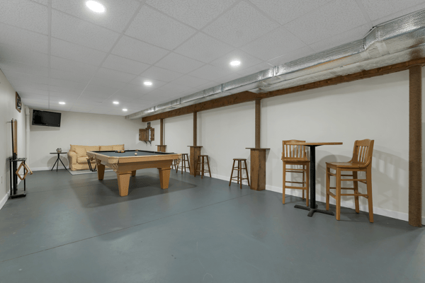 Spacious recreational area featuring a pool table, bar seating, and ample room for entertainment activities.