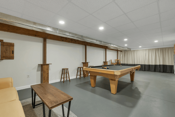 Spacious basement leisure area featuring a pool table, bar seating, and ample room for entertainment.