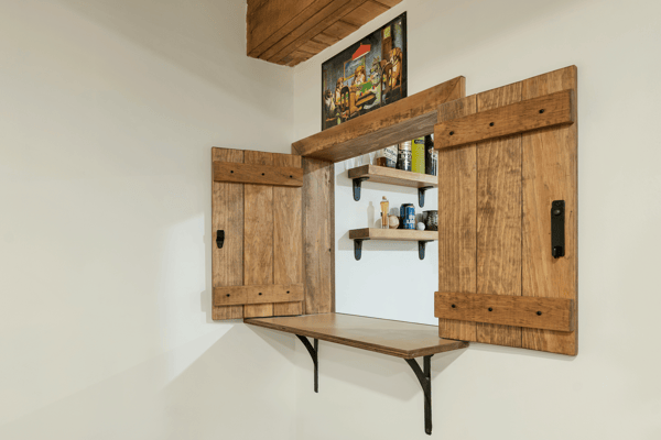This unique nook features rustic wooden shutters and shelving, perfect for displaying decor or storing essentials.