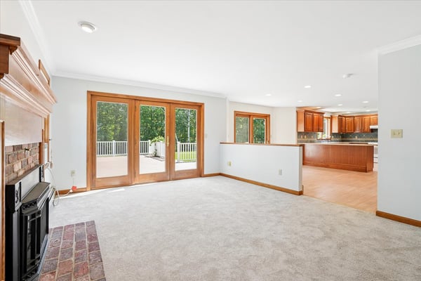 Bright open living space featuring a fireplace, large windows, and seamless access to outdoor entertaining.
