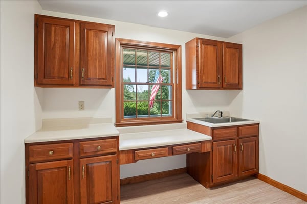 Bright kitchen space featuring ample cabinetry, a large window with outdoor views, and efficient countertop area.