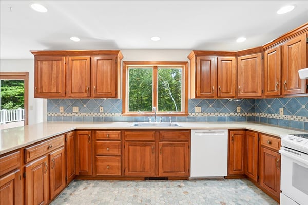 This functional kitchen features rich wood cabinetry, ample counter space, and bright natural light.