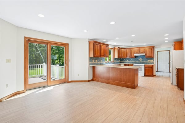 Modern kitchen featuring ample natural light, updated cabinetry, and direct access to an outdoor deck.