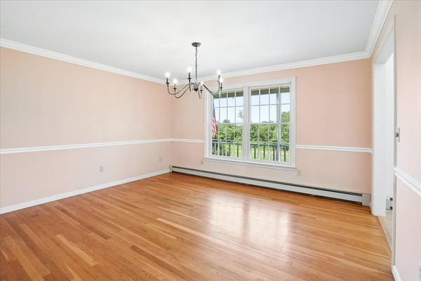 Spacious room with abundant natural light, featuring hardwood floors and a picturesque view. Perfect for customization.