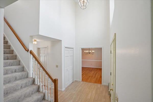 Spacious entryway featuring high ceilings and seamless flow to the inviting dining area and staircase.