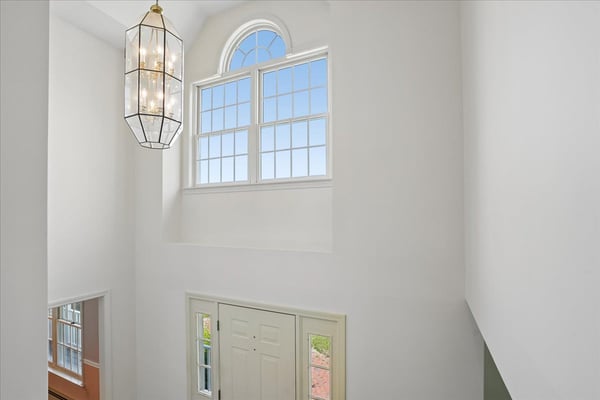 Expansive entryway featuring a statement light fixture and large windows that invite natural light.