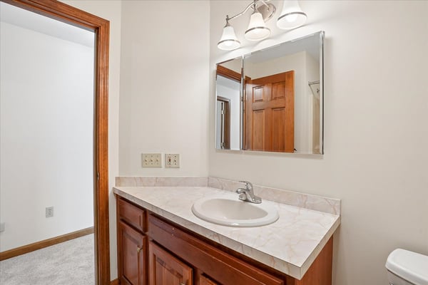 Bright bathroom featuring a spacious vanity with ample counter space and a convenient mirror overhead.