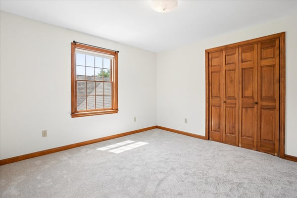Bright and airy room featuring large windows, ample natural light, and well-crafted wooden closet doors.
