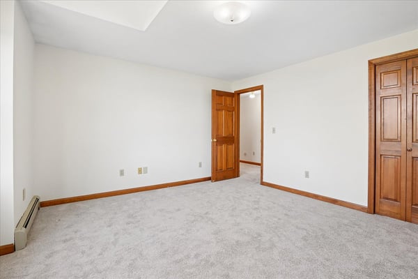 Spacious, versatile room with neutral tones, ample natural light, and convenient access to adjacent areas.